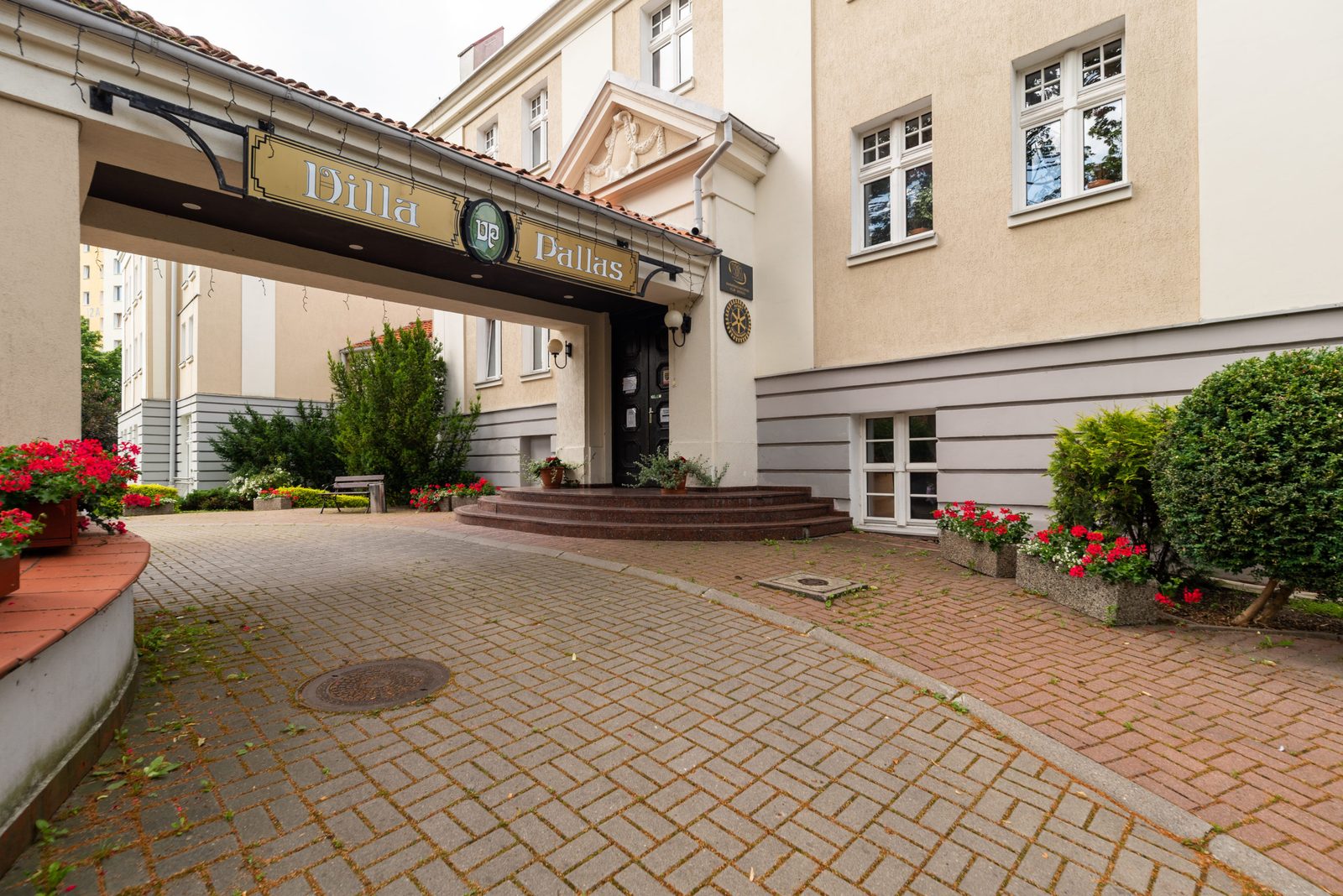 Wejście Hotel Villa Pallas — brukowany podjazd i szyld